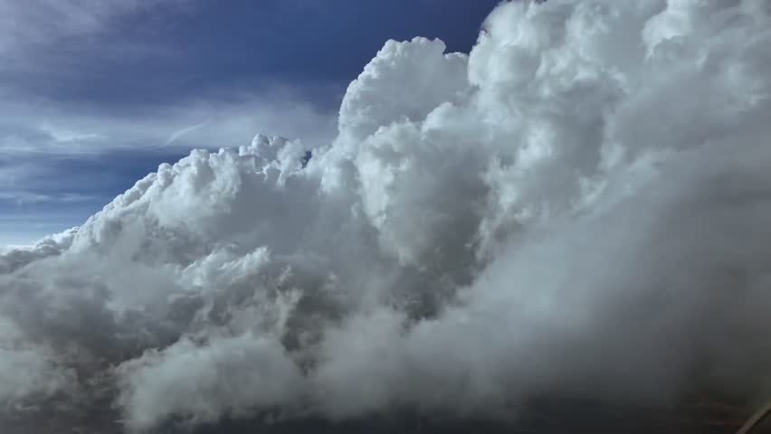 An immersive pilot’s perspective from cockpit flying into threatening storm clouds. An aerial footage taken from a jet cockpit, flying into a darkening sky.