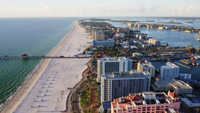 Clearwater Beach stretches in a long ribbon of white sand along the Gulf of Mexico, with a pier, high-rise resorts, and winding inland waterways completing the coastal view.