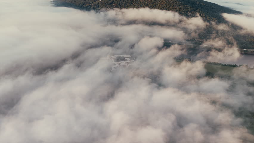 Aerial drone view of Lookout Mountain in Chattanooga, Tennessee, partially covered in mist and clouds.
