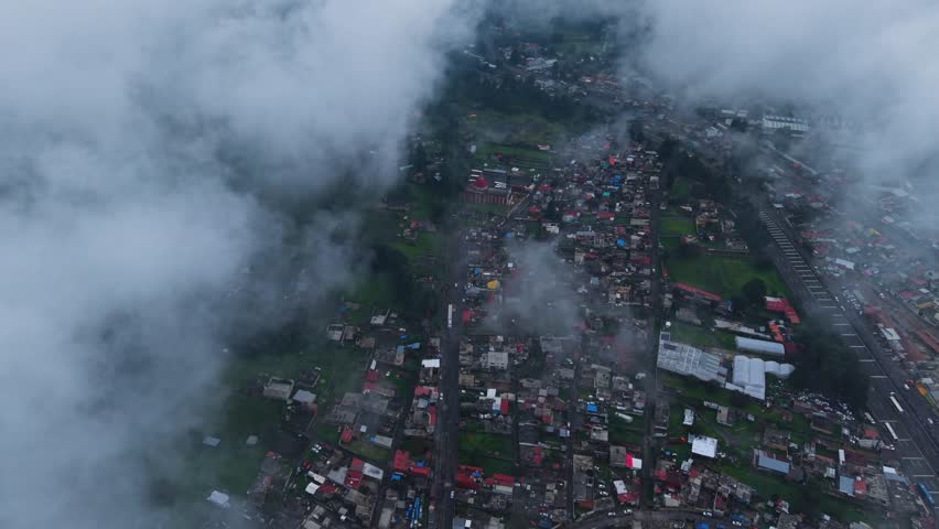 High-altitude drone shot of a village in state of Morelos, among clouds