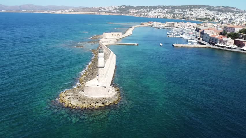 Drone footage of cruise ship entering Chania port near the historic lighthouse
