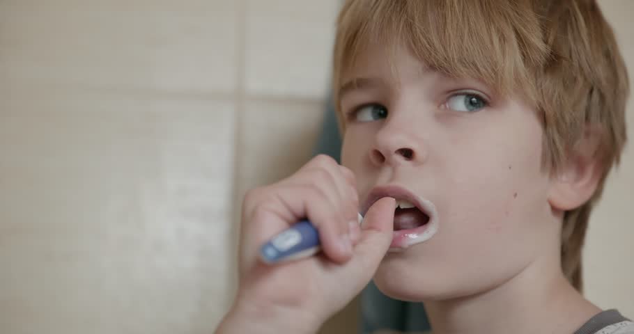 Boy Brushes Teeth in Bathroom in the Morning. 4K 10-bit