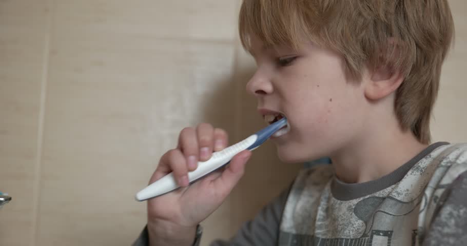 Boy Brushes Teeth in Bathroom in the Morning. 4K 10-bit