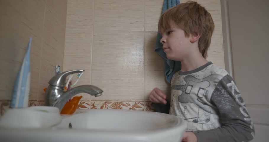 Boy Brushes Teeth in Bathroom in the Morning. 4K 10-bit