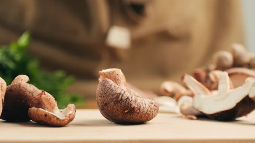 Fresh Royal oyster mushrooms, chef cooking on a wooden cutting board with knife in cafe asian restaurant kitchen, vibrant scene of food preparation