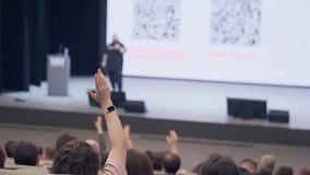Focused view on audience with presenter on stage giving lecture during formal conference session. - Powered by Shutterstock - Get 15% off with code: PIKWIZARD15
