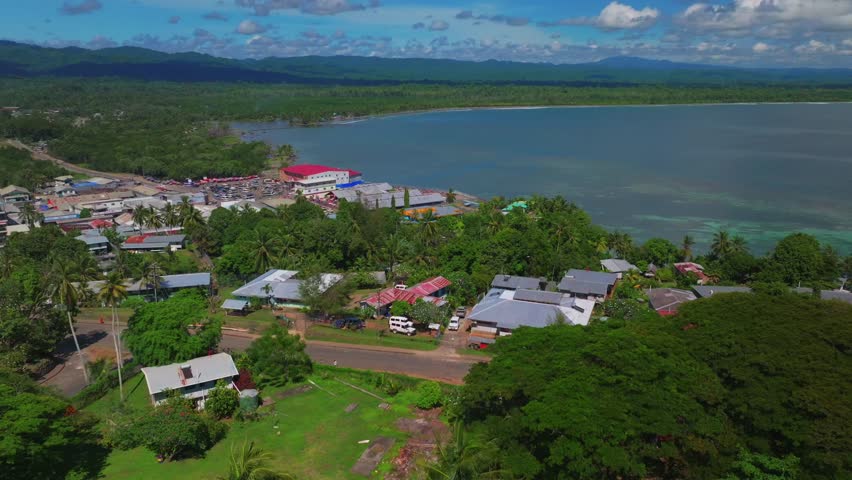 Wewak Hill Fish Market cars buildings village Boram road Wewak Papua New Guinea aerial drone downtown coastal town Sundaun Market Dogreto Bay Cape Wom Bismark Sea sunny blue sky morning forward up