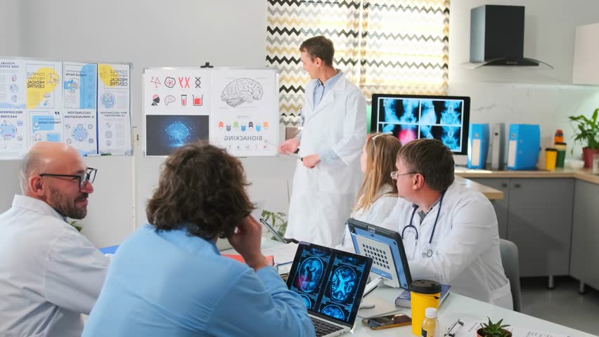 Healthcare professionals in white coats gathered at a seminar. Doctor explains biohacking concepts with pointer, showing brain diagrams and medical illustrations on board. Audience listens attentively