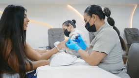 Beautician wearing face mask carefully applying nail polish to a customer in a beauty salon - Powered by Shutterstock - Get 15% off with code: PIKWIZARD15