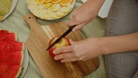 Cutting apple on cutting board with knife. Preparing apple slices for fruit platter. Slicing fresh apple into pieces for serving - Powered by Shutterstock - Get 15% off with code: PIKWIZARD15