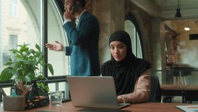 Muslim business team problem job in office woman in hijab typing laptop Indian man angry stressed irritated talking arguing mobile phone call leader annoyed intern secretary female with computer job - Powered by Shutterstock - Get 15% off with code: PIKWIZARD15