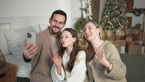 Merry Christmas celebrating. Happy family mother father girl child having video chat in smartphone. Parents kid recording video in social network. Family having video call with friends family - Powered by Shutterstock - Get 15% off with code: PIKWIZARD15