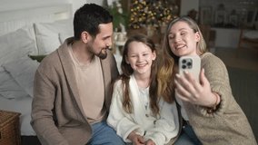 Merry Christmas celebrating. Happy family mother father girl child having video chat in smartphone. Parents kid recording video in social network. Family having video call with friends family - Powered by Shutterstock - Get 15% off with code: PIKWIZARD15
