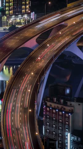 4K Timelapse aerial view of highway bridge with busy traffic in nigth Taipei city. Beautiful Timelapsed freeway in cityscape. Cars ligth exposure. Mountain Xindian