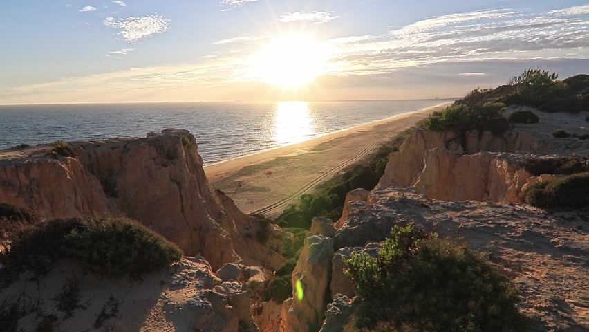 Sunset over Arenosillo cliffs and sandy beach in Doñana, Huelva, Spain. Scenic coastal view, ocean horizon, travel, and nature background.