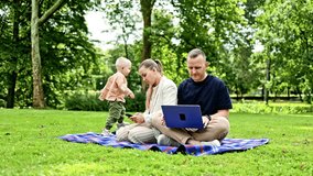 A young family couple works outdoors with a laptop while their child plays nearby. A happy family couple with a child are relaxing outdoors and working remotely on a laptop. - Powered by Shutterstock - Get 15% off with code: PIKWIZARD15