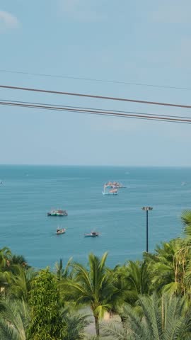 Modern cable car gondola ride over tropical seaside with fishing boats and turquoise sea on Phu Quoc island, Vietnam at Sunset town. Hon Thom cable car cabin. Tourism technology and infrastructure