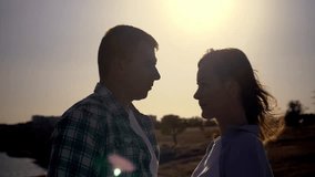 Silhouette portrait of a young couple standing close, looking at each other at sunset. Romantic slow motion captures love, intimacy, and emotional connection in nature.  - Powered by Shutterstock - Get 15% off with code: PIKWIZARD15