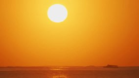 Silhouette of a fast boat on the horizon line in the ocean under the sun disk during sunset.Vertical video - Powered by Shutterstock - Get 15% off with code: PIKWIZARD15