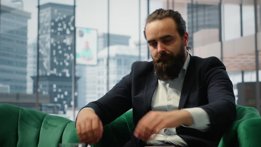 Male corporate leader buries his face in his hands due to frustration, pressure of a declining economy and battling the stress of a failing company. Business downfall and bankruptcy. Camera B.