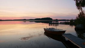 Beautiful Clear Lake with a Boat next to Wooden Pier in Beautiful Summer Evening in Northern Sweden, Ripples in Water Creating Calm and Tranquil Atmosphere, 4K Static Shot - Powered by Shutterstock - Get 15% off with code: PIKWIZARD15