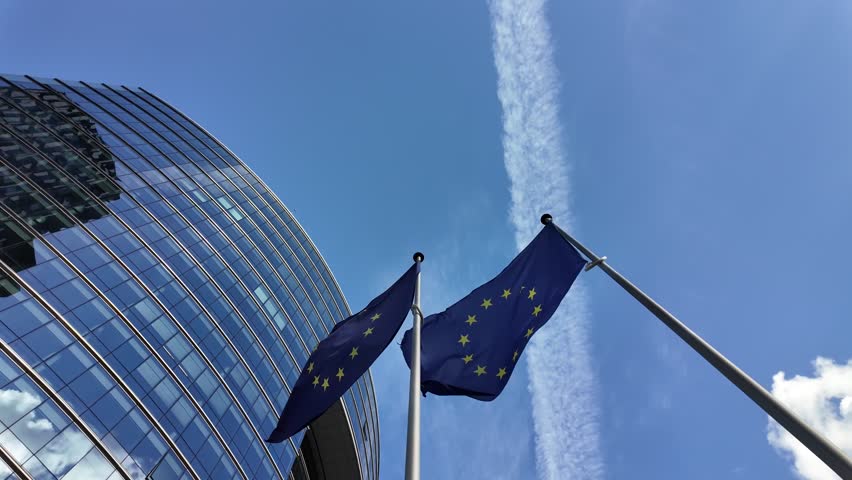 Slow motion of EU flags fluttering outside the Lex Building in Brussels