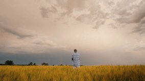 A Young Farmer Stands Alone In A Field Of Wheat Against A Stormy Sky 4k video - Powered by Shutterstock - Get 15% off with code: PIKWIZARD15