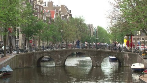 Iconic arched Amsterdam bridge over a canal.