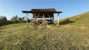 Rustic wooden hut with tiled roof standing on grassy slope in countryside. - Powered by Shutterstock - Get 15% off with code: PIKWIZARD15