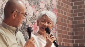 Asian elderly people enjoying karaoke at a care facility - Powered by Shutterstock - Get 15% off with code: PIKWIZARD15