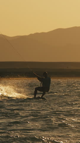Kite surfer jumping over ocean waves in slow motion golden hour tropical sunset extreme sport freedom lifestyle travel destination adventure holiday energy summer beach paradise motivation