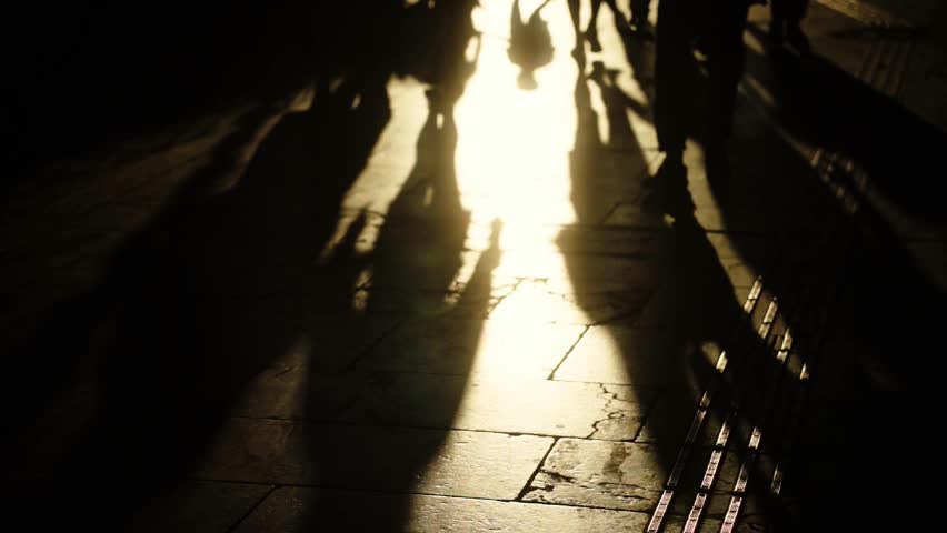 Long Shadows of People Walking on a Street at Night, Creating an Urban Abstract Pattern