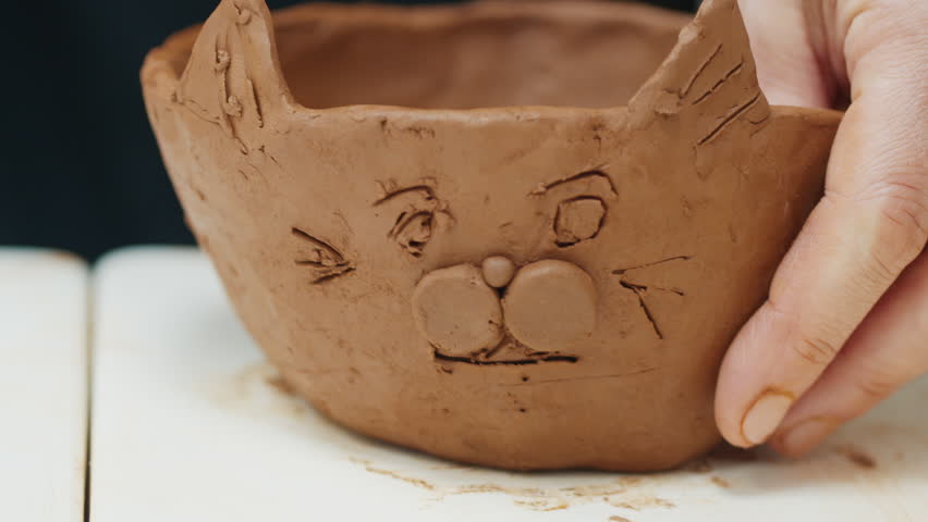 Girl learns pottery and shapes the clay in the pottery workshop during masterclass