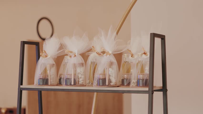wedding favors with honey jars and gifts wrapped in white tulle on display shelf