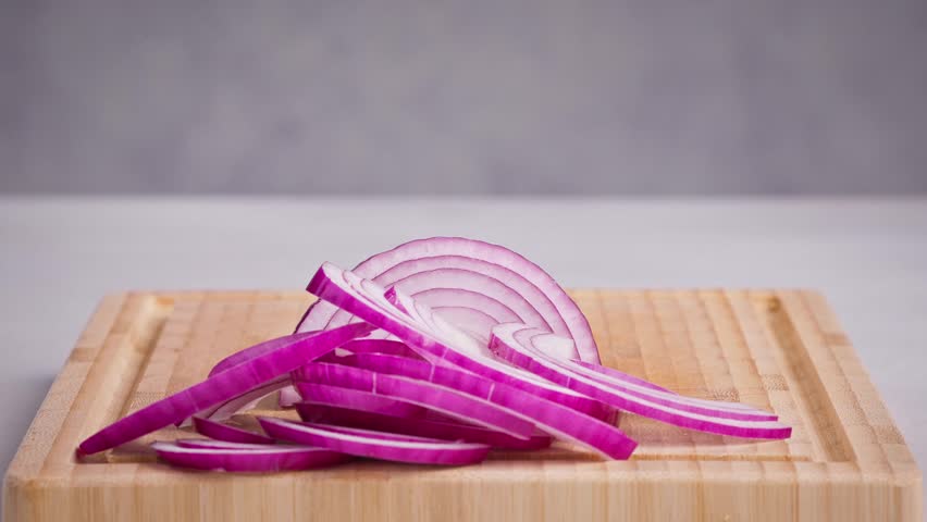 chef cut onion on cutting board with sharp knife for making healthy meal and cooking, cook cutting red juicy onions for making salad, food closeup in kitchen