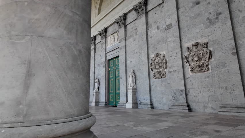 Classical facade of the Esztergom Basilica with statues and coat of arms, showing architectural details and stone ornaments. Push forward shot
