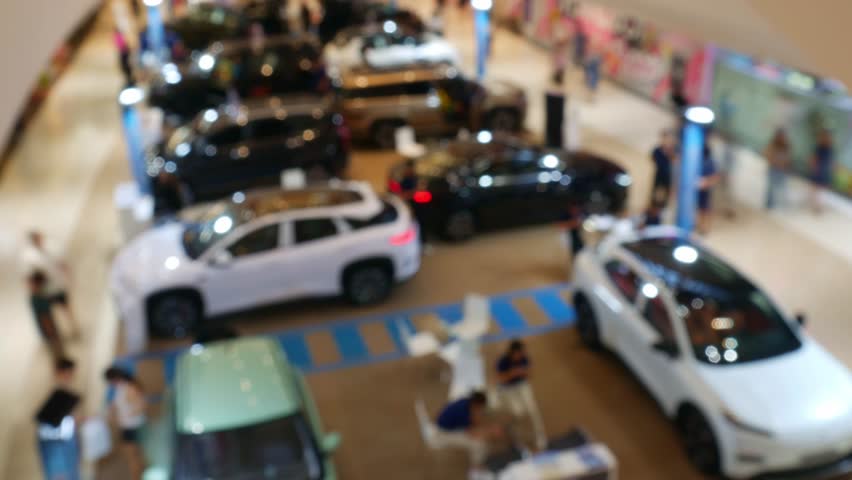 Time Lapse Blurred Car Exhibition in Shopping Mall - Defocused Auto Show Display with Bokeh Effect in Modern Showroom