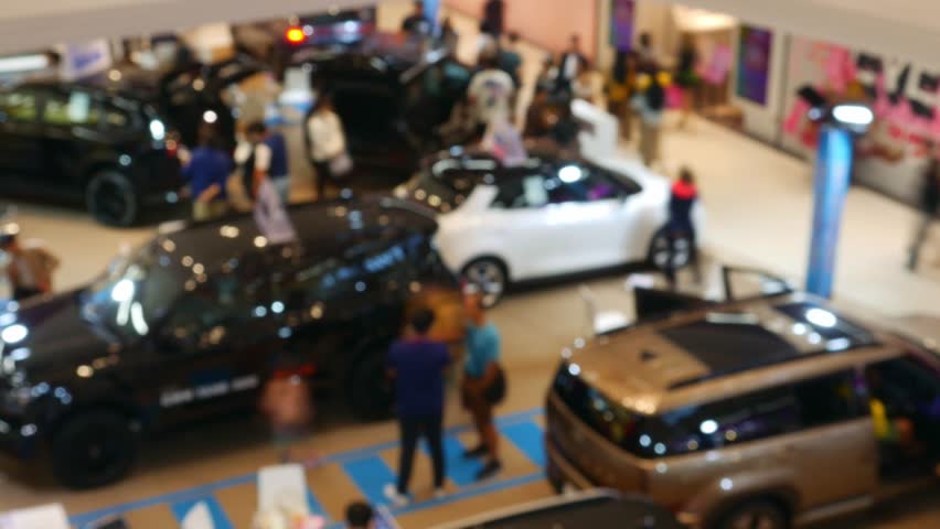Time Lapse Blurred Car Exhibition in Shopping Mall - Defocused Auto Show Display with Bokeh Effect in Modern Showroom