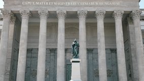 The imposing neoclassical facade of the Esztergom Basilica, featuring corinthian columns and a dome, stands tall against a clear blue sky - Powered by Shutterstock - Get 15% off with code: PIKWIZARD15