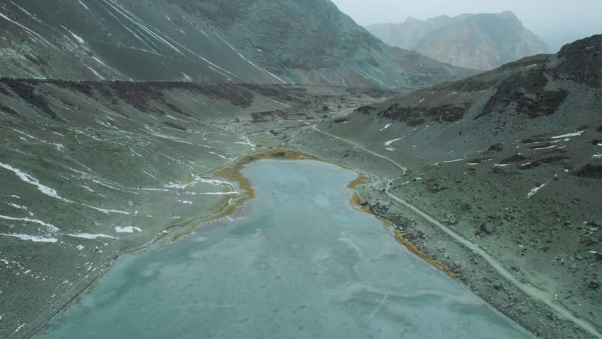 Beautiful drone view of frozen lake in Gilgit Baltistan, Pakistan. Beautiful snow capped mountains, valley, cloudy weather, travelling, spa, nature, northern areas of Pakistan, tourism, beauty. 