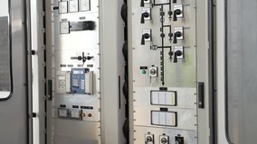 Asian male engineer inspecting industrial control panel, wearing safety vest and helmet, checking electrical wiring for system maintenance, power distribution, workplace safety in factory environment - Powered by Shutterstock - Get 15% off with code: PIKWIZARD15