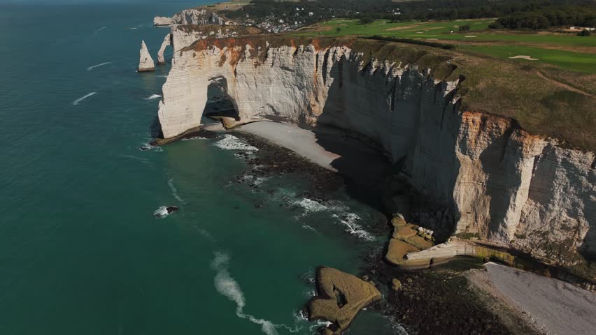 Aerial panorama of Étretat’s chalk cliffs, arches, and sea stacks along the Normandy coast.