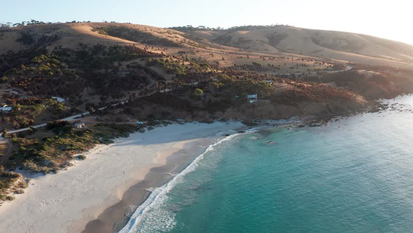 Reverse aerial view of white sand beach with golden hour light, Snelling Beach, Kangaroo Island, South Australia