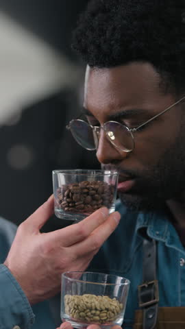 Professional happy African Caucasian men workers specialists smelling cups different coffee scent intensity contrast tasting session craftsmanship small business expertise roasted beans arabica indoor