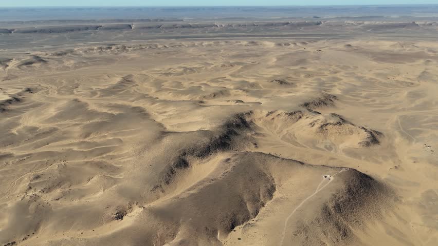 Drone aerial footage of rocky desert landscape in Mauritania. Sahara wilderness with sandy plains, hills, geological formations