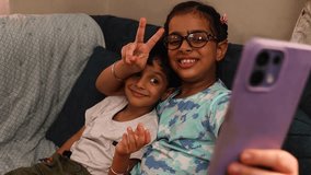 Brother and sister smiling while taking a selfie together on a mobile phone, enjoying sibling bonding - Powered by Shutterstock - Get 15% off with code: PIKWIZARD15