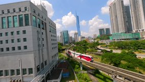 FPV drone shot of red urban train gliding along elevated tracks through Kuala Lumpur, Malaysia. Modern cityscape, public transport, and skyline - ideal for city life and travel themes. - Powered by Shutterstock - Get 15% off with code: PIKWIZARD15