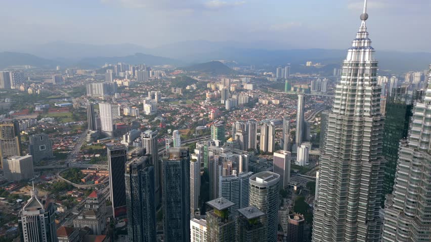 Aerial panoramic view of Kuala Lumpur, Malaysia. Modern skyscrapers and dense cityscape with mountains in the distance. Urban landscape, architecture, travel, and Southeast Asia themes.