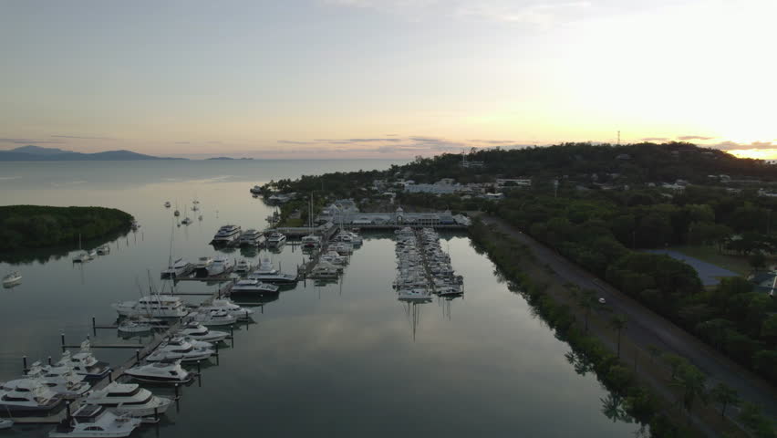 Drone approaching the Port Douglas marina, sunny evening in Queensland, Australia