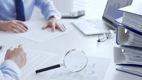 Business team working with financial data using laptop and magnifying glass, analyzing charts and checking reports, close up. Audit and taxes in business - Powered by Shutterstock - Get 15% off with code: PIKWIZARD15